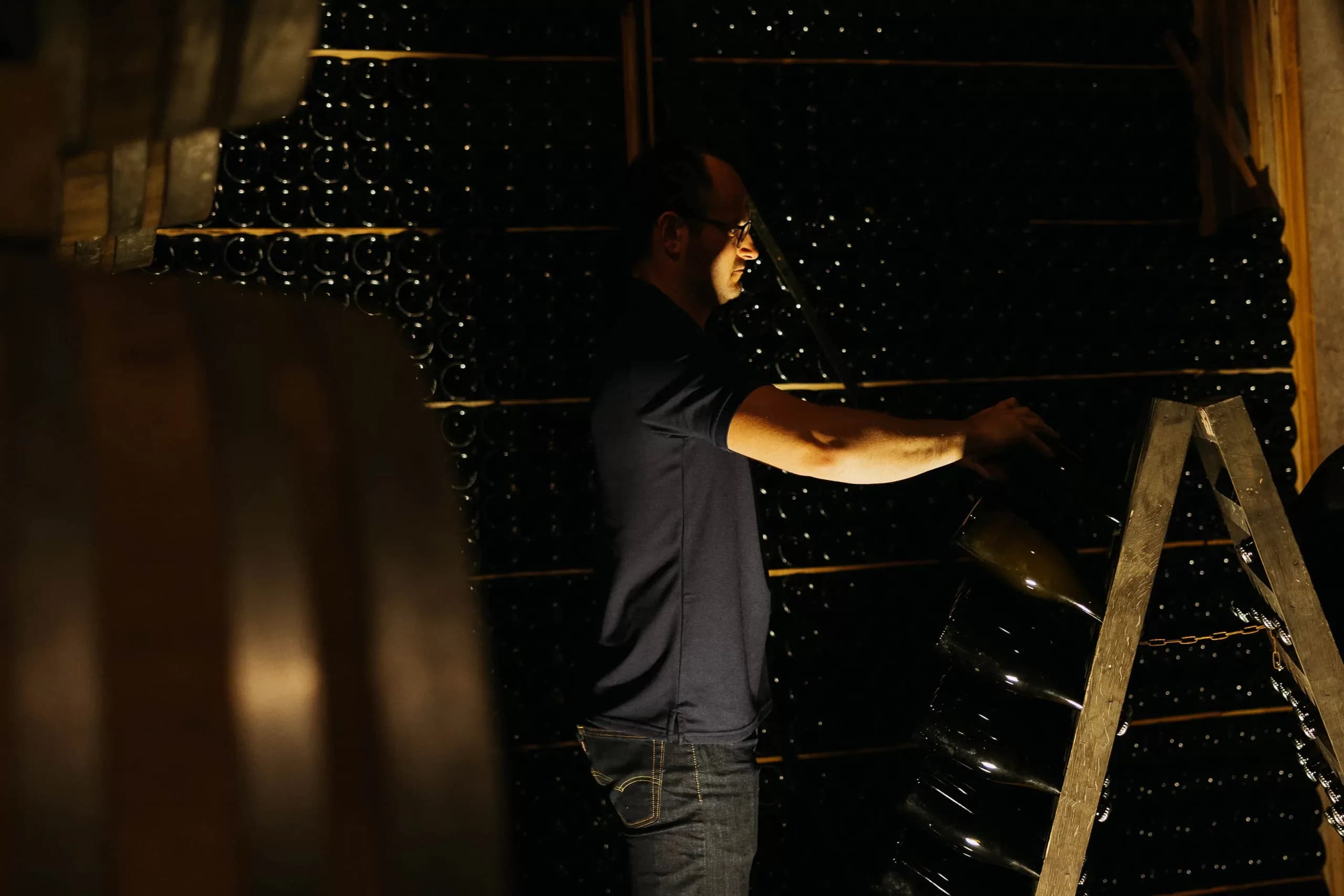 Sébastien LeSeurre riddling bottles on the wooden rack, turning each one by hand