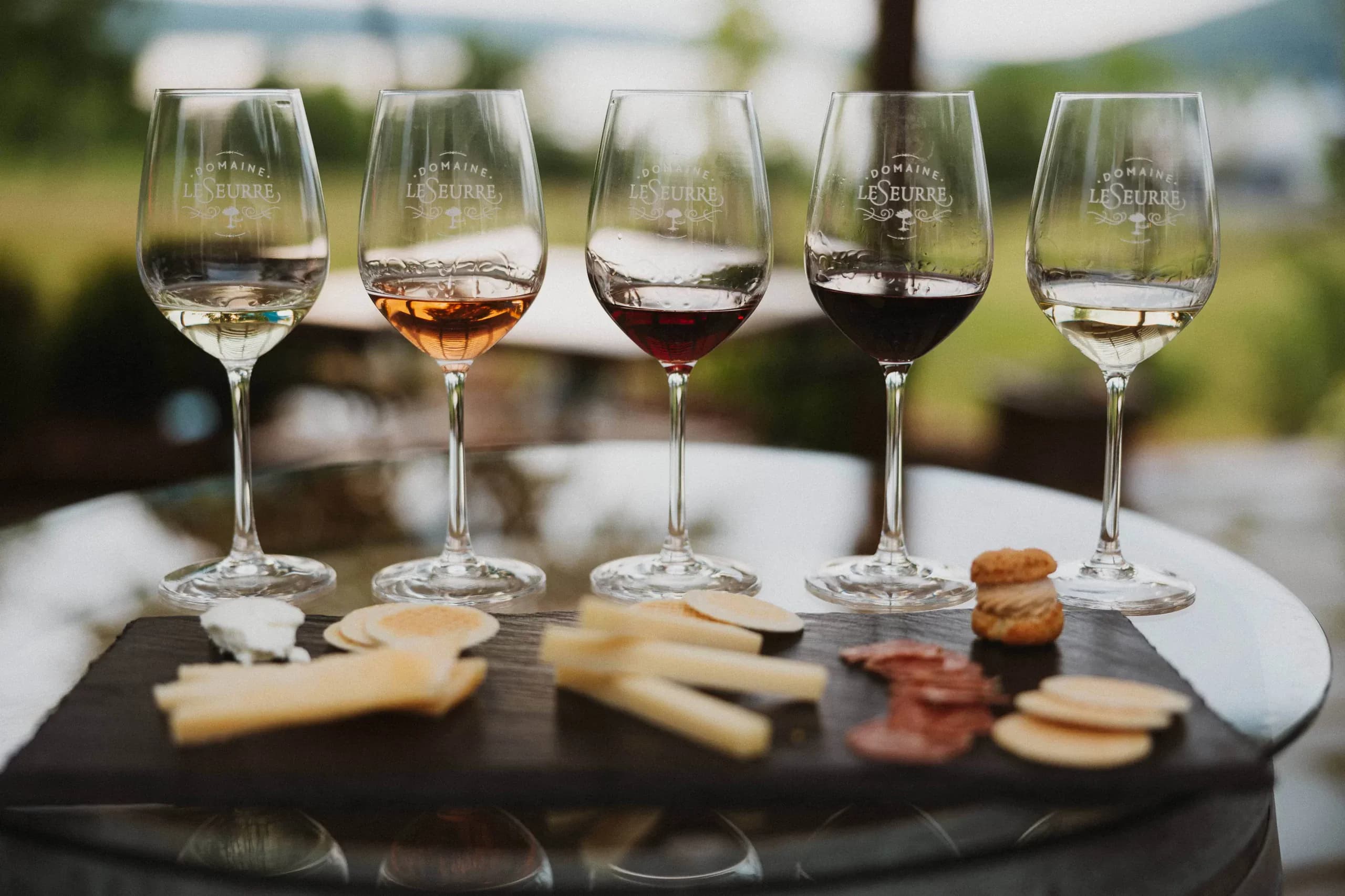 A flight of wines poured side by side on the tasting bar at Domaine LeSeurre